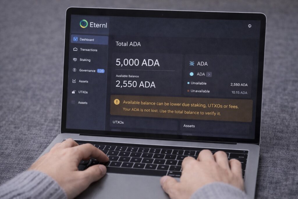 Mis manos usando una laptop con Eternl Wallet abierta mostrando diferencia entre saldo total y saldo disponible de ADA